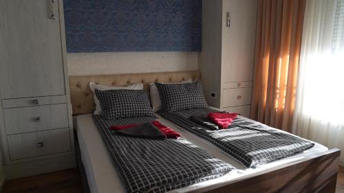 Bella studios في كروشيفاتس: سريرين مع وسائد حمراء عليهم في غرفة النوم
