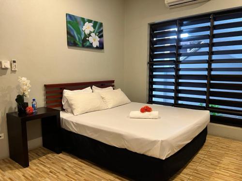 a bedroom with a bed with a flower on it at Garden Apartments in Nadi