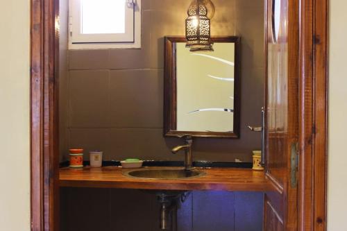 a bathroom with a sink and a mirror at La petite maison sur la colline - Benslimane 