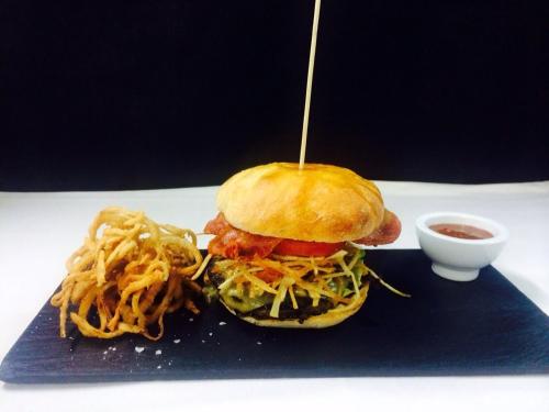 a sandwich on a blue plate with noodles and sauce at Hotel Restaurante El Valles 4 ESTRELLAS in Briviesca