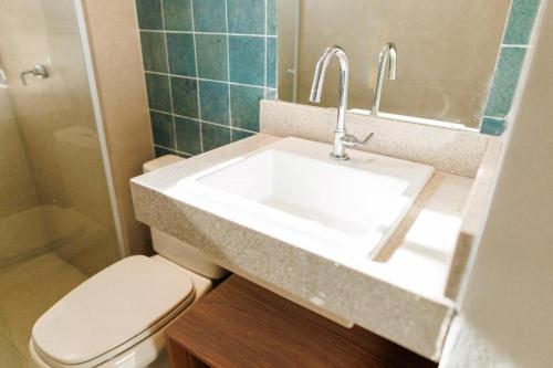 a bathroom with a white sink and a toilet at Aqualand Park Resort in Salinópolis