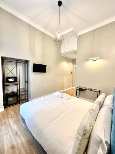 a bedroom with a large white bed and a tv at AD Suites Nazionale in Rome
