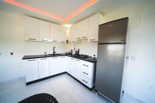 a kitchen with white cabinets and a stainless steel refrigerator at Ferme au cœur la Forêt de Maamoura - Près de Rabat in Rabat