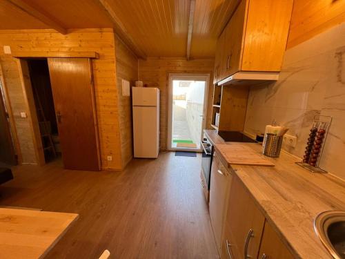 una cucina con frigorifero bianco e pavimento in legno di Casa da Praia a Carvalhal