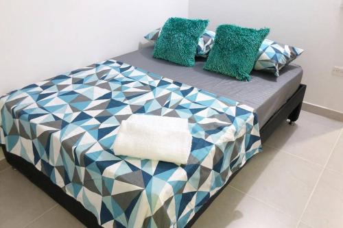 a bed with colorful pillows on top of it at Hermoso apartamento en Doradal Antioquia in Doradal