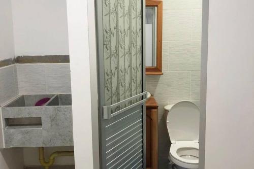 a bathroom with a toilet and a sink and a door at Hermoso apartamento en Doradal Antioquia in Doradal