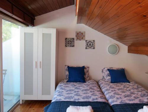 a bedroom with two beds with blue pillows at White House Lisbon Hostel in Lisbon