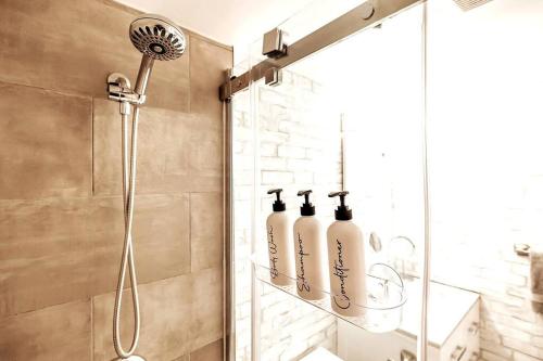 a shower with three bottles on a shelf in a bathroom at Mountainside Studio Bliss Pool, Hot Tubs, At the Mountain in Blue Mountains