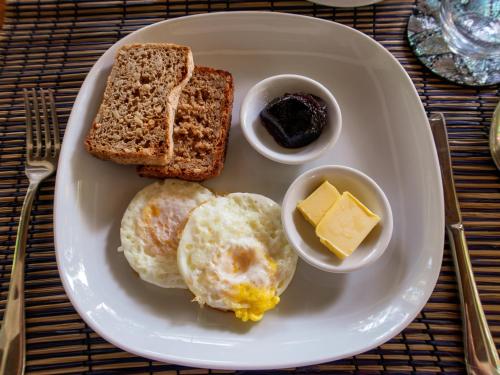 a plate of eggs and toast with butter and jam at The Dream Beach Resort in Taytay