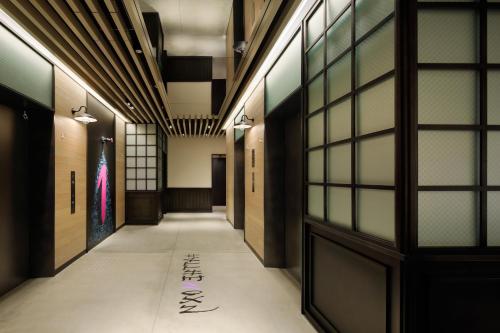 a corridor of a building with writing on the floor at Moxy Osaka Shin Umeda in Osaka