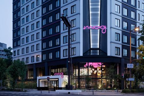un bâtiment avec une enseigne sur le côté dans l'établissement Moxy Osaka Umeda, à Osaka