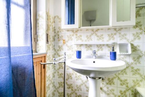 uma casa de banho com um lavatório branco e um espelho. em casa Gabriella em SantʼEufemia Lamezia