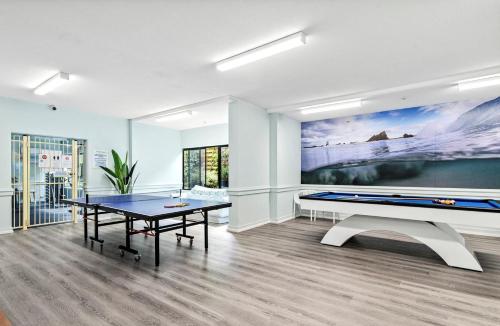 uma sala de jantar com uma mesa de pingue-pongue e um quadro grande em Two Bedroom Ocean View Penthouse at Pelican Sands em Gold Coast