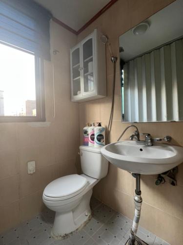 a bathroom with a toilet and a sink and a mirror at Sangmin Sweet in Daejeon