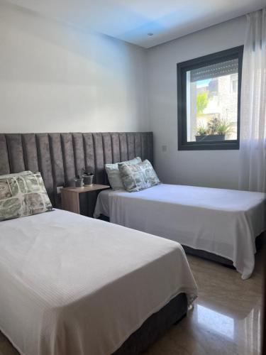 een slaapkamer met 2 bedden en een raam bij Perla Garden Bay in Casablanca