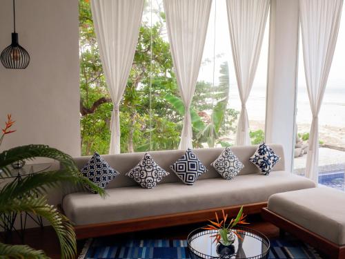 a living room with a couch with blue and white pillows at The Dream Beach Resort in Taytay