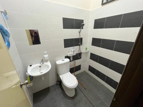 a bathroom with a toilet and a sink at Hakim Harmoni Homestay Air Hitam in Air Hitam