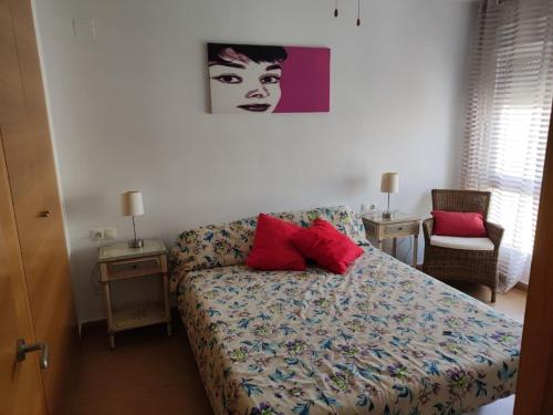 um quarto com uma cama com duas almofadas vermelhas em Beautiful apartment in El Verger with sea views em El Verger