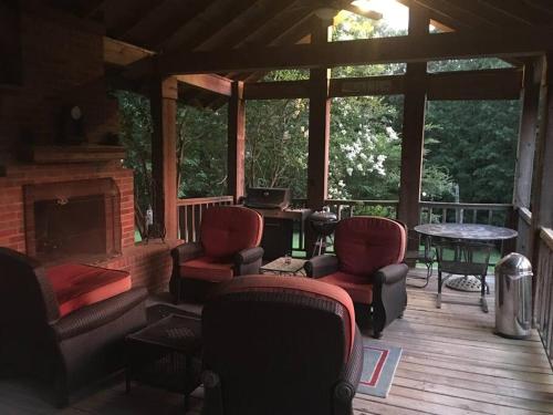 a screened in porch with chairs and a fireplace at Oxford Chalet Getaway with Lake/Beach Access in Oxford