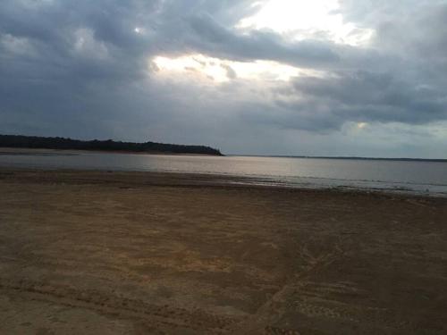 a beach with a cloudy sky and the water at Oxford Chalet Getaway with Lake/Beach Access in Oxford