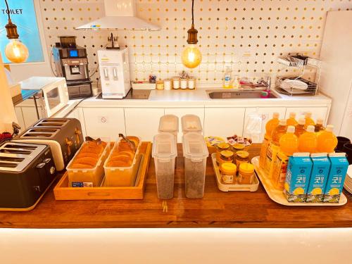 Una cocina con un mostrador con botellas de jugo de naranja. en OYO Hostel Myeongdong 5, en Seúl