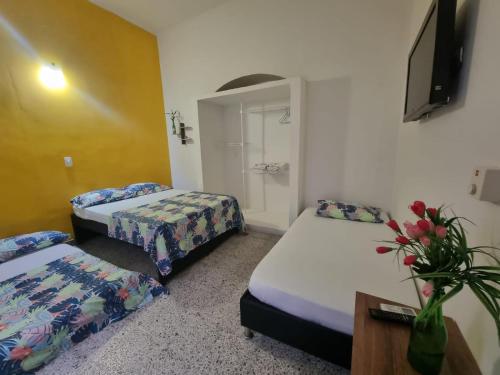 a hotel room with two beds and a tv at Casa de Luna in La Dorada