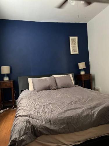 a bed in a bedroom with a blue wall at Bright, big family escape, W/parking, dogs welcome in Oak Park