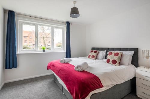 a bedroom with a large bed with a red blanket at Two bedroom flat near Colchester Hospital with free parking and internet in Mile End