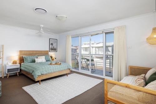 a bedroom with a bed and a large window at Sandcastles at the Beach - Linen Supplied & Beds Ready on Arrival in Fingal Bay