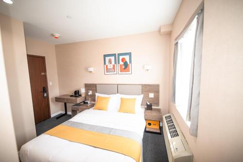 a hotel room with a bed and a desk at Flushing Garden Hotel in Queens