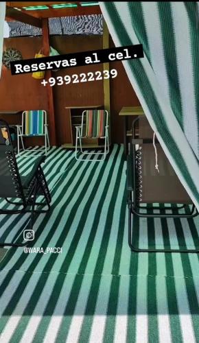 Habitación con alfombra de rayas verdes y blancas en Villa frontera home, en Arica