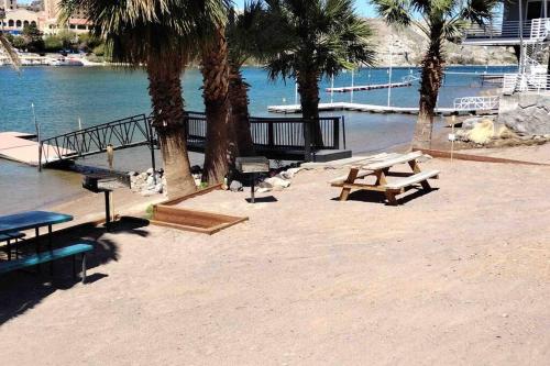 a picnic table and benches next to the water at 3 bedroom, 2 bath 1 min walk to the beach in Bullhead City