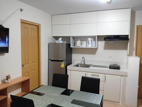 una cucina con tavolo, lavandino e frigorifero di 2- bedroom condo in Davao a Davao