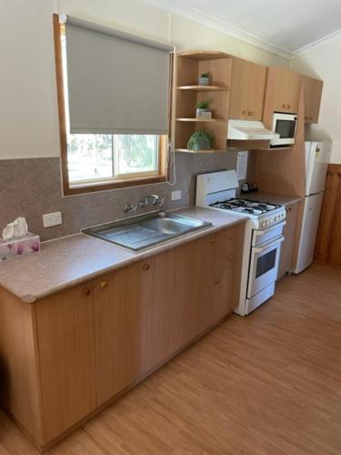 a kitchen with a sink and a stove top oven at Sandy Hollow Tourist Retreat in Sandy Hollow