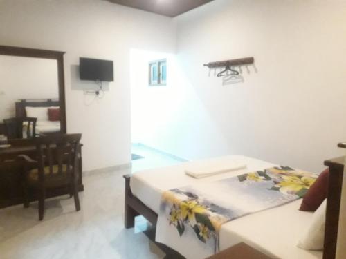 a room with a bed and a table and a mirror at Enara Luxury Stay in Katugastota