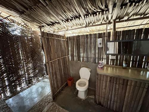 a bathroom with a toilet in a wooden stall at Mistica Island Hostel - Isla Palma in Isla Palma