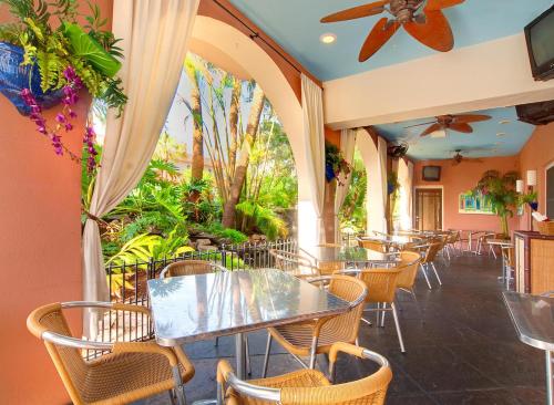 um restaurante com mesas, cadeiras e plantas em Tahitian Inn Boutique Hotel Tampa em Tampa