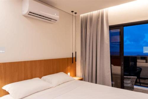 a bedroom with a white bed and a window at Salinas Premium Resort in Salinópolis