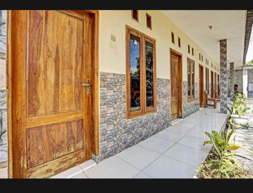 a row of wooden doors on a building at guest house RUMAH KALOKA in Triwung