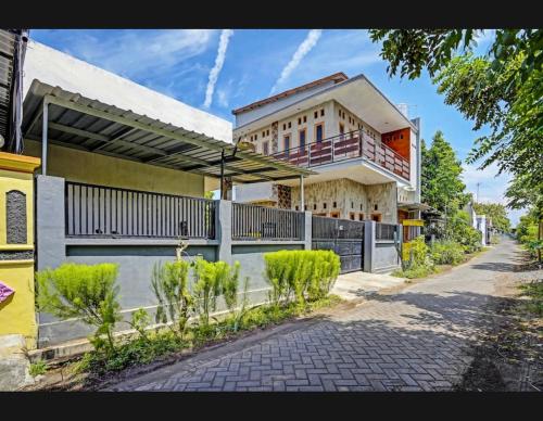 a building with a balcony on the side of a street at guest house RUMAH KALOKA in Triwung