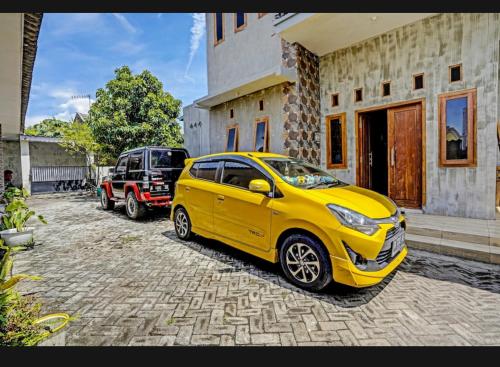 a yellow car parked in front of a house at guest house RUMAH KALOKA in Triwung