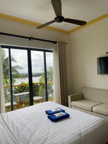 a bedroom with a bed and a couch and a window at Coral Riverside Homestay & Hostel in Hoi An