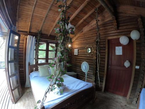 a bedroom with a swing in a log cabin at Mistica Island Hostel - Isla Palma in Isla Palma