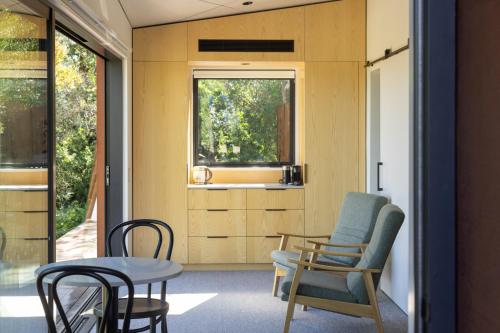 a room with chairs and a table and a window at Tussock Hill Vineyard Retreats in Christchurch