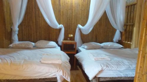 een slaapkamer met 2 bedden met witte lakens en gordijnen bij Homestay Chung Thêm in Hoàng Su Phì