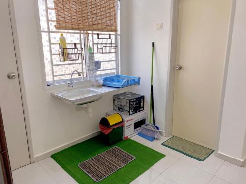 a kitchen with a sink and a green rug at Nasrah Homestay Alor Gajah in Kampong Alor Gajah