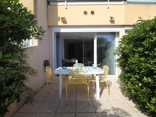 une table et des chaises assises sur une terrasse dans l'établissement Studio Cabine 6 Pers. avec Terrasse, Loggia et Parking Privé à 2 Pas de la Plage - FR-1-307-234, au Grau-du-Roi