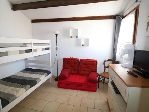 1 dormitorio con silla roja y litera en Appartement Le Grau-du-Roi, 2 pièces, 4 personnes - FR-1-307-235, en Le Grau-du-Roi