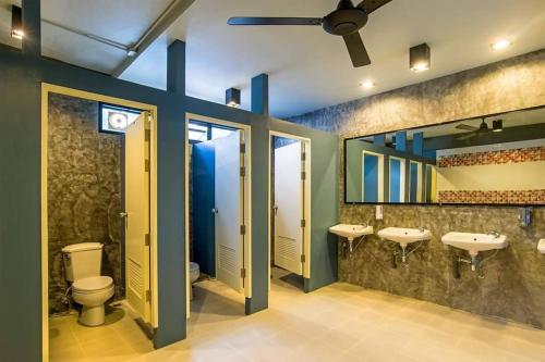 a bathroom with two sinks and two mirrors at Amity Poshtel in Krabi town