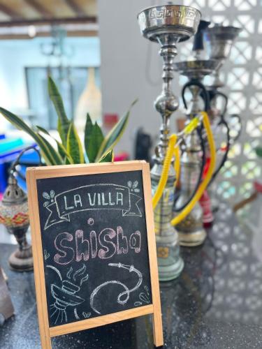 a chalkboard sign that says la vile shisu on a table at La Villa Langkawi - Private Pool in Pantai Cenang
